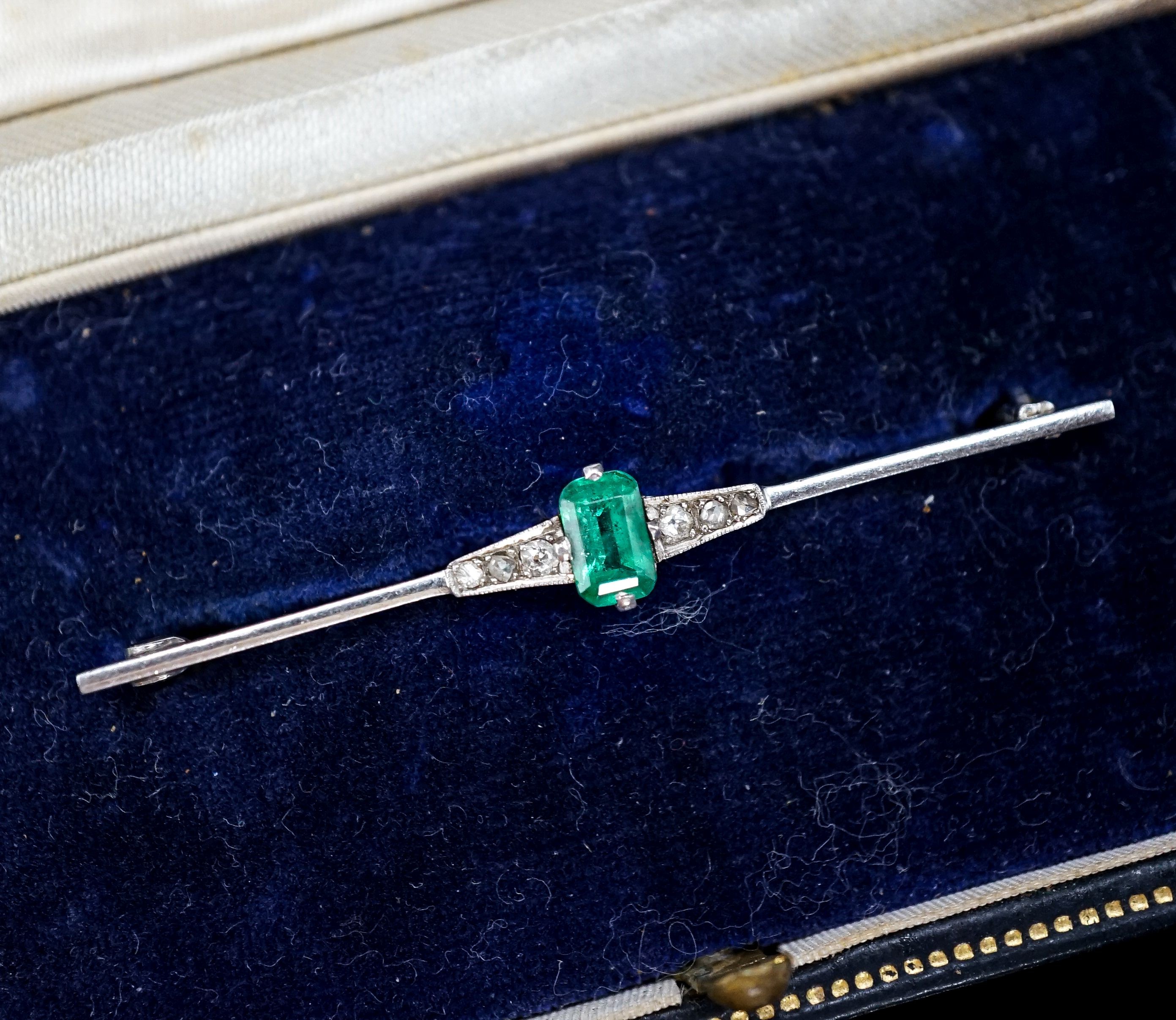 A boxed 1920's white metal (stamped pt), emerald and diamond chip set bar brooch, 51mm, gross weight 3.1 grams.